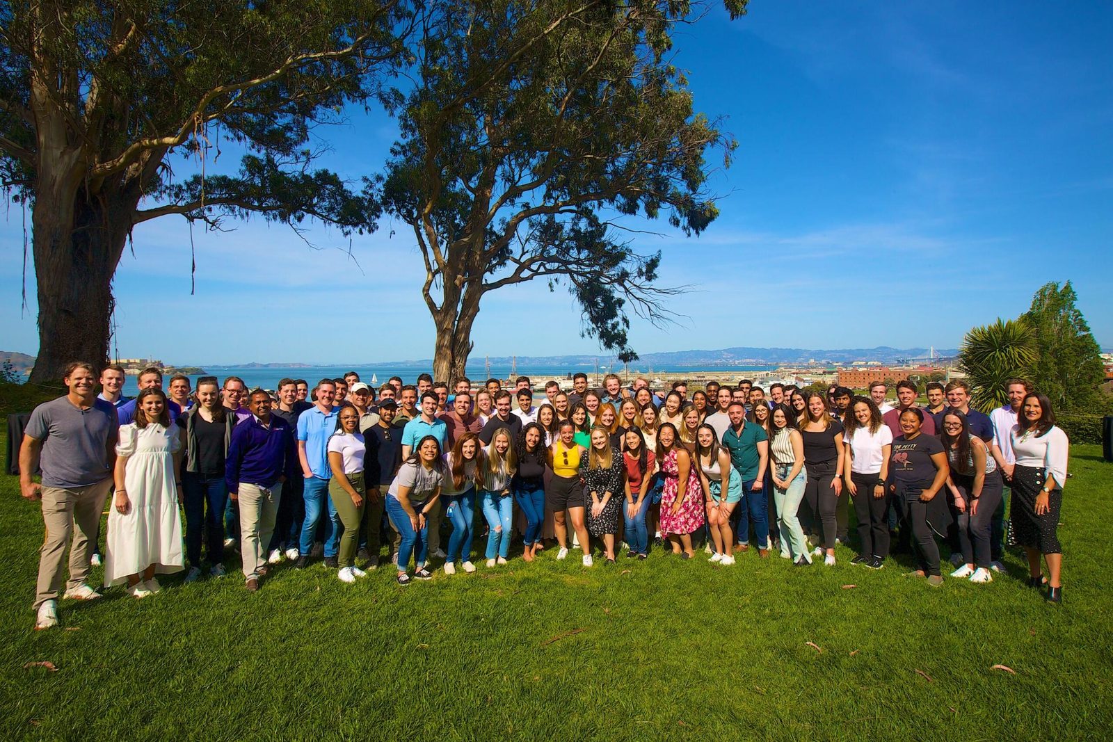 A large group of people gathered outdoors for a team photograph