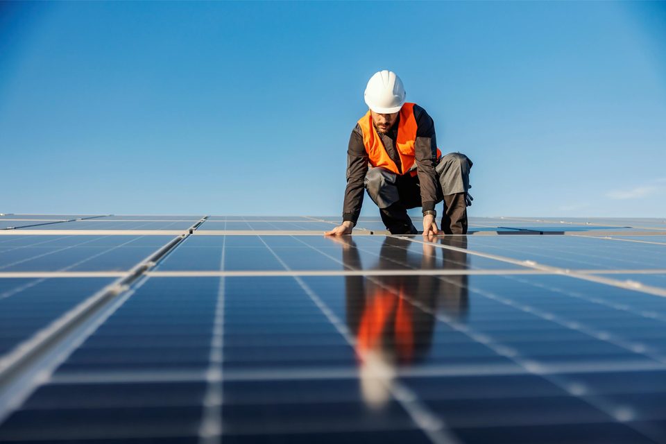 An engineer installing panels on a rooftop solar array